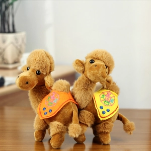 Detailed view of plush camel toys with vibrant embroidered saddles on a wooden surface