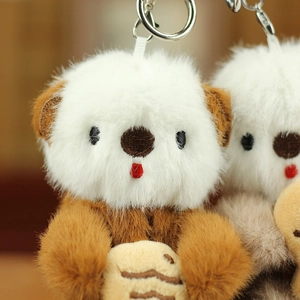 Dettaglio di simpatici portachiavi a forma di lontra in morbido peluche con conchiglia