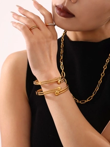 Dettaglio di bracciali doppi placcati in oro 18k e collana a catena spessa su modella