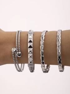 Dettaglio del set di quattro bracciali argento con borchie a piramide e trame