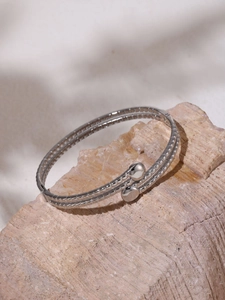 Dettaglio del bracciale rigido a doppio strato argentato con trama a scaglie incise