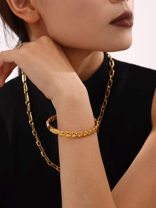 Détail d'un bracelet gourmette coeur en acier inoxydable plaqué or 18 carats