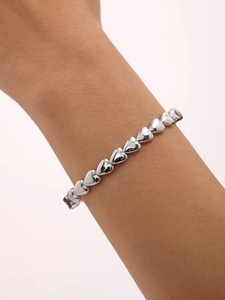 Vue détaillée d'un bracelet à maillons cœur argenté avec finition polie porté au poignet