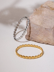 Détail de bracelets en forme de cœur imbriqués aux finitions or et argent polies