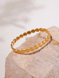 Détail du bracelet cœur en acier inoxydable plaqué or 18K sur socle en pierre