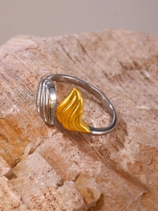 Dettaglio macro di anello bicolore geometrico placcato oro 18K su pietra materica