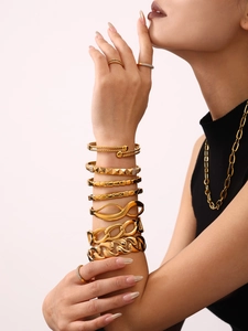 Detailed close-up of premium 18K gold plated bangle stack and rings set on model