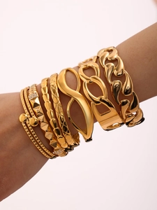 Close-up of a stacked set of 18K gold plated titanium bangles with Cuban chain and cubic zirconia