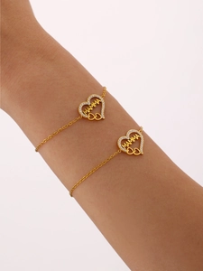 Détail du bracelet coeur plaqué or 18K avec pendentif zircon MAMMA sur poignet femme