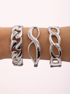 Detailed view of three polished silver titanium steel bracelets on a model wrist