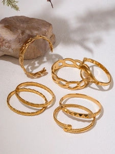 Detailed close-up of 18K gold-plated stainless steel bracelet set on a natural stone