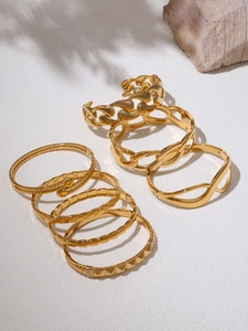 Detail of 18K gold PVD plated bracelets featuring chain, mesh, and studded textures