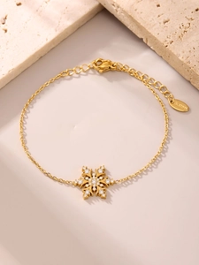 Detalle macro de pulsera de copo de nieve bañada en oro de 18K con circonitas y cierre de mosquetón