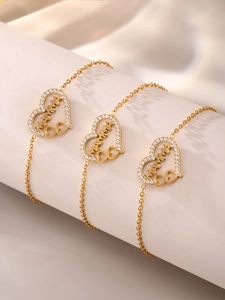 Détail de trois bracelets cœur MAMMA dorés avec incrustation de zircons sur support velours