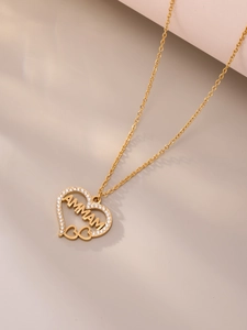 Détail d'un pendentif cœur doré avec lettrage MAMMA et cristaux micro-pavés brillants