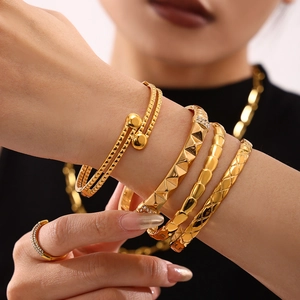 Set of four gold PVD plated stainless steel bangles with textured geometric patterns