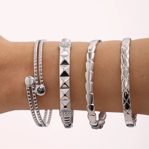 Set of four silver titanium bracelets featuring pyramid studs and quilted texture patterns