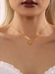 Close-up van een fonkelende gouden sneeuwvlokketting met zirkoon pavé gedragen door model