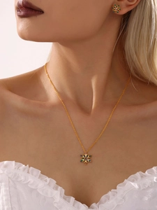 Detailopname van een gouden sneeuwvlok sieradenset met kleurrijke zirkoonstenen en ketting