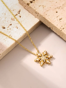 Detail van de fonkelende zirkoon sneeuwvlok hanger aan 18K vergulde ketting