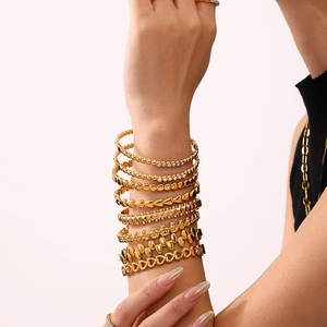 Set minimalistischer 18K vergoldeter Titan-Armbänder mit Zirkonia am Handgelenk eines Models