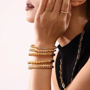 Nahaufnahme von minimalistischen 18K vergoldeten Armbändern und Ringen mit Zirkonia-Steinen