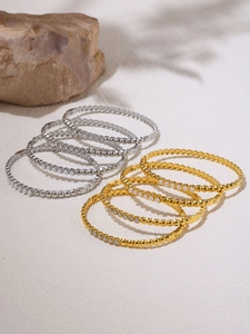 Macro view of gold and silver beaded bracelets with cubic zirconia and pearls on sand