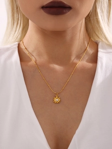 Détail du collier pendentif tournesol avec perle sur chaîne dorée porté par un mannequin