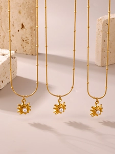 Détail de trois colliers perle tournesol plaqués or 18K sur des pierres naturelles