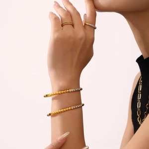 Elegant gold-plated stainless steel bangle with pavé zircon stones on a model wrist