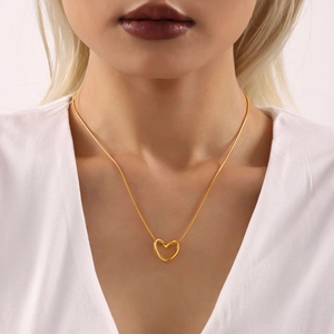 Minimalistische Herz-Halskette mit 18K Vergoldung getragen von einem Modell am Dekolleté