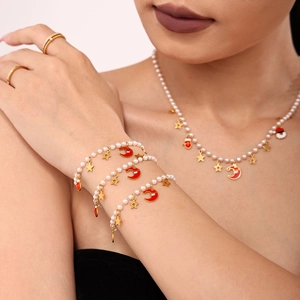 Detailansicht der geschichteten Weihnachtsperlenarmbänder und Halskette mit Emaille-Anhängern