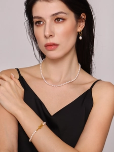Close-up of Baroque freshwater pearl jewelry set with gold OT clasp on a fashion model