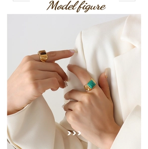 Detailed view of wide twisted gold rings featuring tiger eye and malachite gemstones