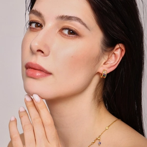 Ensemble boucles d'oreilles et collier dorés avec pierres arc-en-ciel sur mannequin
