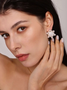 Gros plan sur une boucle d'oreille de luxe avec grappe de perles et base dorée