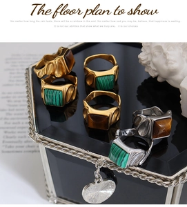 Detailed view of vintage wide-band rings with tiger eye and malachite stones