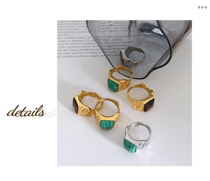 Detail of vintage square tiger eye and malachite rings with hammered metal texture