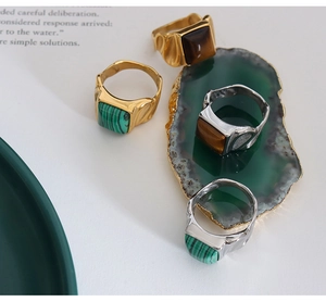 Macro detail of square tiger eye and malachite rings in gold and silver settings