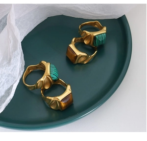 Detailed view of vintage gold rings featuring green malachite and brown tiger eye stones