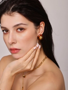 Detail of vintage 18K gold plated heart necklace and amber resin earring on a model