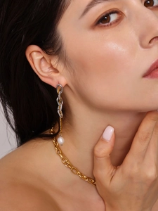 Dettaglio della collana a catena in oro 18K e orecchini con perle d'acqua dolce su modella