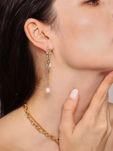 Dettaglio di orecchini a catena placcati in oro 18K con perle d'acqua dolce su una modella