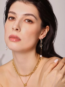 Dettaglio di orecchini a catena e collana a strati con perle d'acqua dolce placcati oro