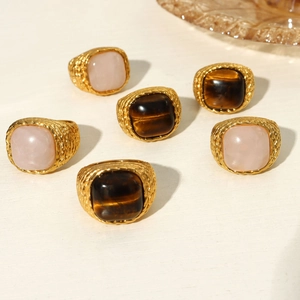 Detail of six vintage 18K gold plated rings set with tiger eye and pink quartz stones