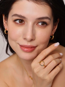 Close-up of gold jewelry set with hollow colorful gemstone ring and zircon earrings