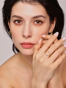 Detail of gold hollow-out ring with micro-pave zircons worn on model finger
