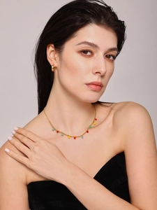 Close-up of gold chain necklace featuring colorful heart pendants and zircon earrings