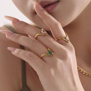 Three-piece set of V-shaped gold rings with colorful pear-cut zircons on a model's hand