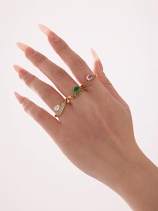Detalle de anillos de gota bañados en oro de 18k con circonitas blancas verdes y rosas